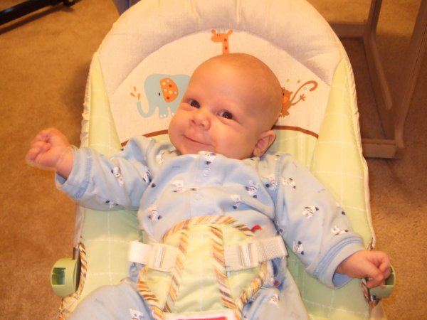 Daniel smiles in his bouncy seat